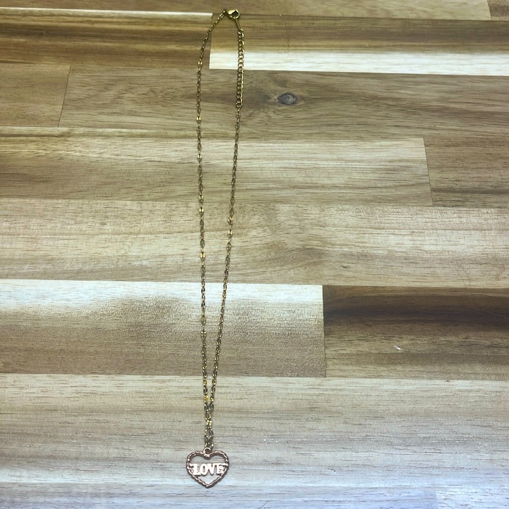 gold necklace with “Love” heart charm